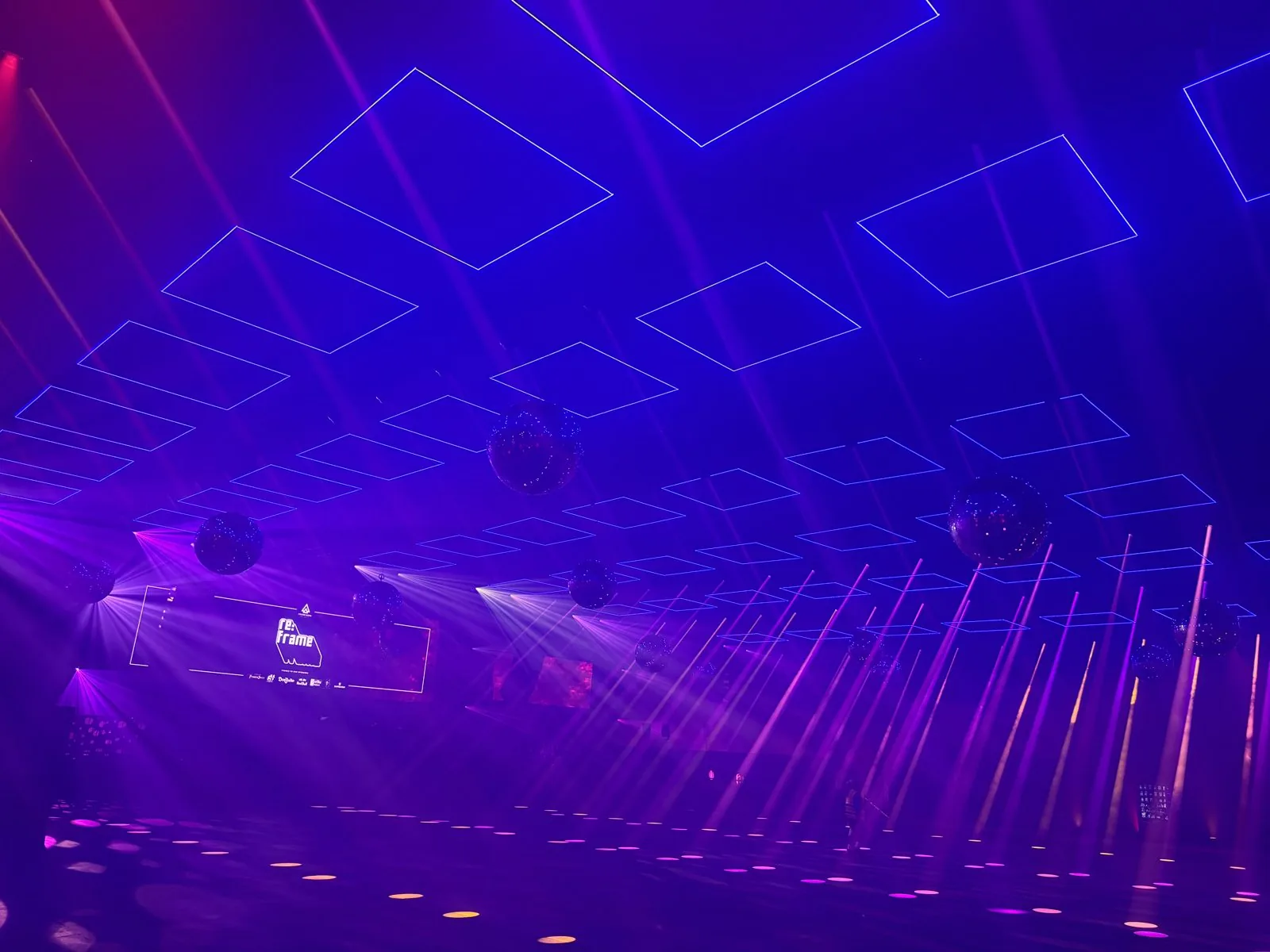 Light beams and kinetic squares filling the room at RE:FRAME