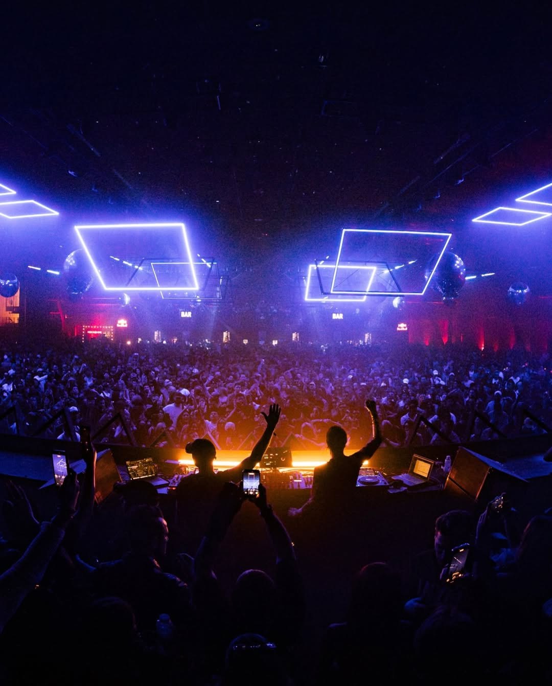 DJs facing a packed crowd under the RE:FRAME kinetic light squares in Los Angeles